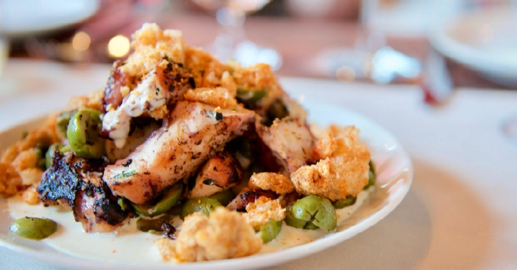 A gourmet plated chicken entrée served with roasted potatoes, vegetables, and artistic sauce drizzles, styled for a fine-dining wedding menu.